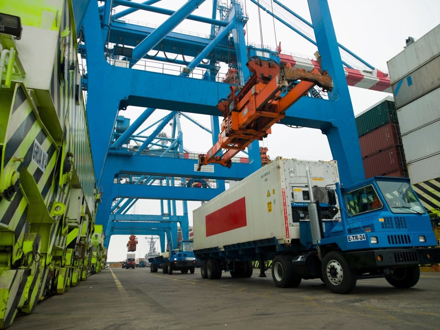 A truck is parked in front of a large blue crane.