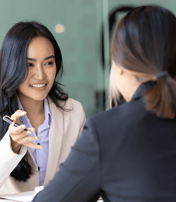 Two women are talking to each other in a room.
