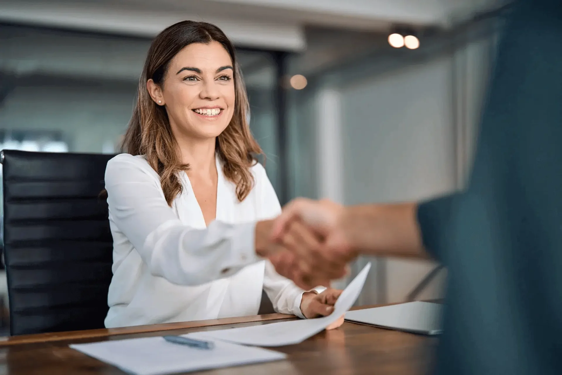 A woman shaking hands with another person.
